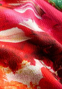 Textiel in levendige rood- en witten met een getextureerd oppervlak, met een gedraaid patroon. Zachte stof met een gelaagde, vloeiende uitstraling.