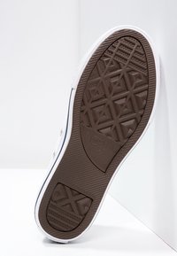 Brun gummiyttermönster med geometriskt mönster, vit mellansula och svarta accenter. Har brandingtexten "Converse All Star" präglad.