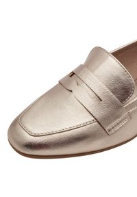 Mocassins en or métallique avec un orteil carré et une semelle plate. Présentent une sangle horizontale sur le dessus du pied avec des découpes. Texture lisse.