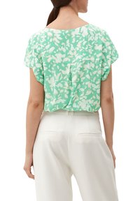 Mintgrünes Blusenshirt mit floralem Druck, kurzen Ärmeln und lockerer Passform. Leicht abgerundeter Saum und weicher, leichter Stoff.