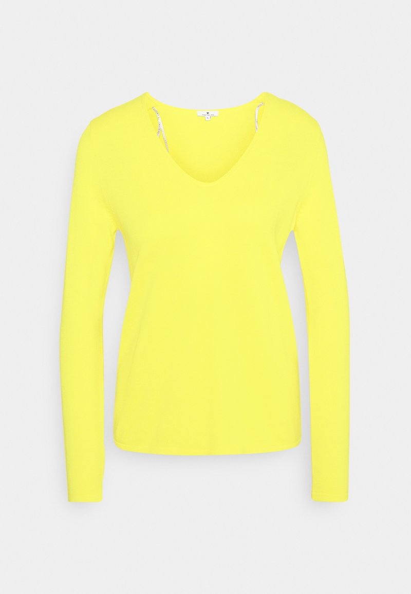 Haut à manches longues jaune vif avec col en V et coupe ajustée, présenté sur un fond gris clair uni.