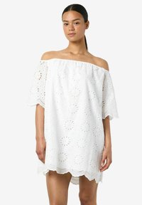 Bela obleka brez naramnic, izdelana iz bombaža broderie anglaise. Značilne so cvetlične izreze, valoviti rob in široki kratki rokavi.
