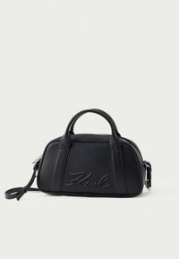 Mala de couro preta com forma arredondada, duas alças superiores e uma tira de ombro removível. Apresenta detalhes em relevo do logótipo.