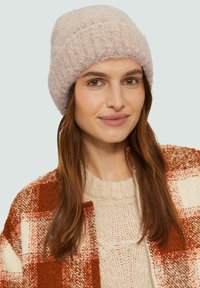 Lichtroze gebreide beanie met een zachte, textuurrijke afwerking, voorzien van een lichtgerolde rand en een aansluitend ontwerp.
