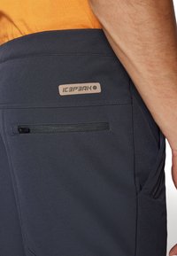 Mornarske hlače za vanjsku upotrebu s glatkom teksturom, s bočnom zatvaračem i izvezenim ICEPEAK logotipom iznad džepa.