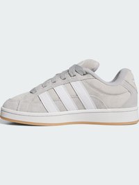 Grå semsket sneaker med tre hvite striper, rund tå, lysegrå snørebånd, polstret krave og en gummiert såle. Enkelt, klassisk design.