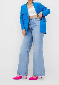 Blue oversized blazer, white cropped top, light blue wide-leg jeans, pink pointed heels. Features buttons, frayed hem on jeans.