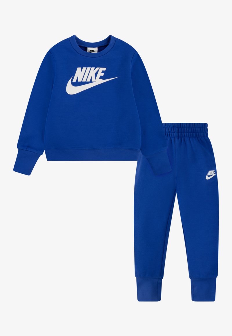 Blaues Sweatshirt mit weißem Nike-Logo auf der Brust, kombiniert mit passenden blauen Jogginghosen, die ein weißes Nike-Logo am Oberschenkel aufweisen. Weicher Stoff, elastische Bündchen.
