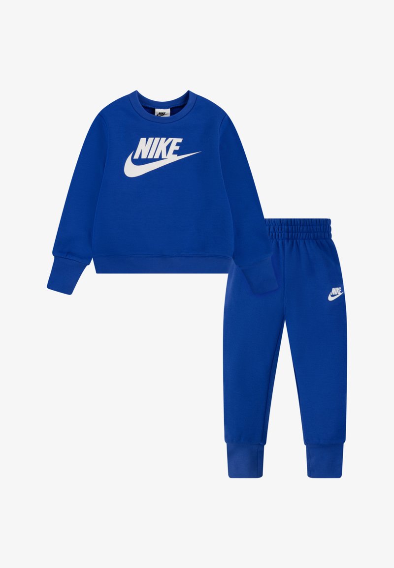 Sweatshirt azul com o logotipo branco da Nike no peito, combinado com calças de fato azuis correspondentes que apresentam o logotipo branco da Nike na coxa. Tecido suave, punhos elásticos.