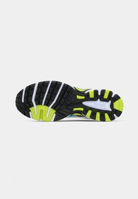 Suola di scarpa da corsa con modelli di battistrada in nero, bianco e giallo neon progettati per trazione e supporto.