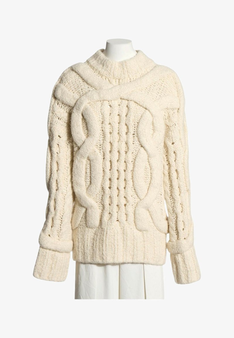 Pull en maille épaisse de couleur crème avec motifs torsadés, poignets et ourlet côtelés, et un col montant côtelé, présenté sur un mannequin blanc.