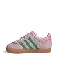 Pink suede sneaker with three green stripes, textured gum sole, and pink heel accent. Features flat laces and rounded toe.