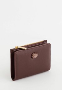 Monedero de cuero texturizado marrón con un cierre dorado y acento de logotipo circular. Diseño compacto con múltiples compartimentos para tarjetas y dinero en efectivo.
