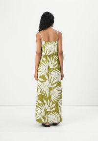 Robe maxi en vert olive avec des motifs de feuilles tropicales blanches, dotée de bretelles spaghetti ajustables et d'une taille élastique pour une coupe décontractée.