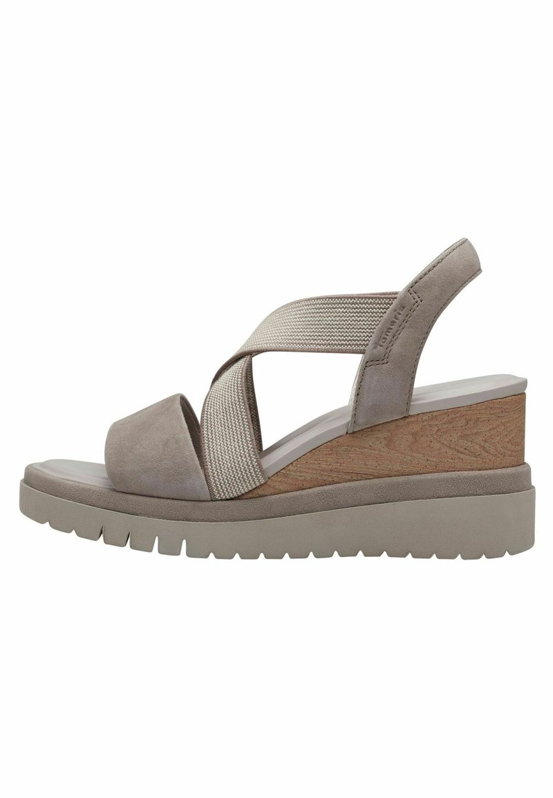 Sandale compensée beige avec brides élastiques croisées, semelle intermédiaire effet bois, semelle intérieure matelassée et semelle extérieure en caoutchouc rainuré.