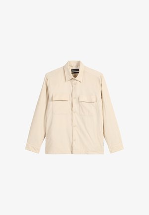 Beige shirt met lange mouwen van een zachte stof, met een kraag, twee borstzakken en een knoopsluiting. Heeft een ontspannen pasvorm.