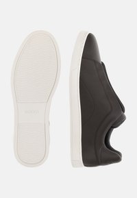 Ruske nahkakengät teksturoidulla pinnalla, valkoinen kumipohja, jossa on aaltoileva kuvio, ja sivuaukko helpompaa pääsyä varten.