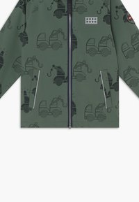 Grüne Kapuzenjacke mit Reißverschluss, die schwarze Lkw-Illustrationen, seitliche Taschen und reflektierende Akzente aufweist. Glatte Textur mit modernem Design.