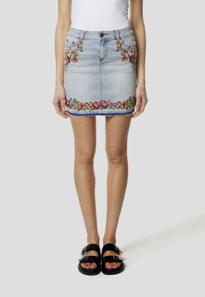 Denim mininederdel med blomsterbroderi i rødt, grønt og blåt langs kanten. Har knappelukning foran og frynset kant.