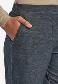 Mörkblå, strukturerade mjukisbyxor med en slät midja och en sidoficka, som visar en avslappnad design och en bekväm passform.