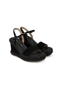 Sandali con tacco a cuneo neri, in suede, con punta aperta e cinturino alla caviglia. Presentano materiale intrecciato attorno al tacco e cuciture bianche a contrasto.