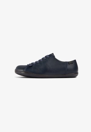 Pantof cu piele de culoare bleumarin, cu vârf rotund, material texturat și șireturi contrastante. Are un profil scăzut și o marcaj subtil pe toc.