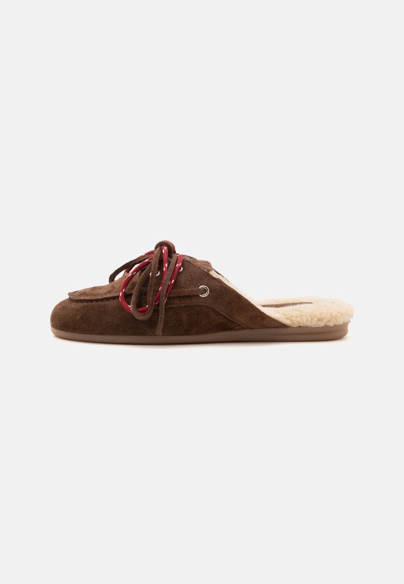 Chausson en daim marron à enfiler avec des lacets rouges et une doublure crème en peluche, montré de profil sur un fond neutre.