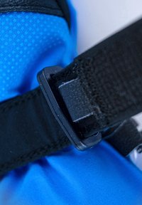 Blaues Gewebe mit strukturierter Oberfläche, ausgestattet mit einem schwarzen Riemen mit einer Kunststoffschnalle und Klettverschluss, der praktische Designelemente hervorhebt.