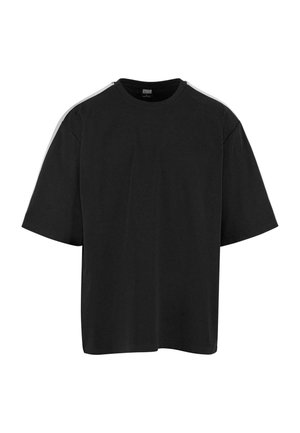 T-shirt noir surdimensionné avec des manches courtes et une bande blanche courant le long du haut de l'épaule et de la manche.