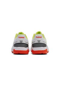 Scarpe da ginnastica bianche con accenti verde lime, strisce nere e suola arancione; presentano un tallone imbottito e un logo del marchio sul retro.