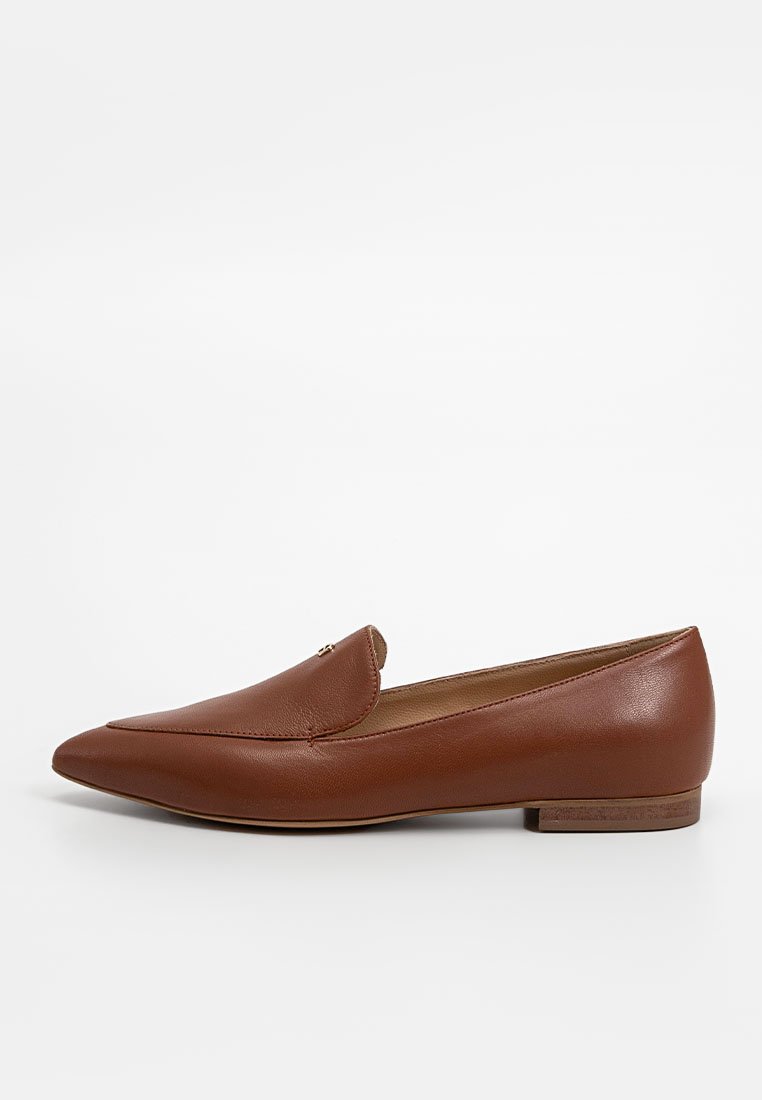 Braune Lederloafers mit spitzem Zeh, subtilen Nähdetails und kleinen Hofer-Elementen. Flacher Absatz und glatte Oberfläche.