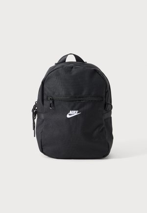 Kis fekete Nike hátizsák elülső cipzáras zsebbel, felső fogantyúval és fehér Nike logóval az elején, egyszínű háttér előtt.