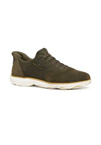 Zapatilla deportiva verde oliva con una combinación de materiales de ante y tela. Presenta una suela blanca, parte superior texturizada y cordones planos. Detalle de marca minimalista.