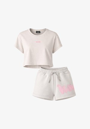 Top corto color beige con maniche corte, logo rosa e pantaloncini beige abbinati con vita elastica e grafica rosa sulla gamba sinistra.