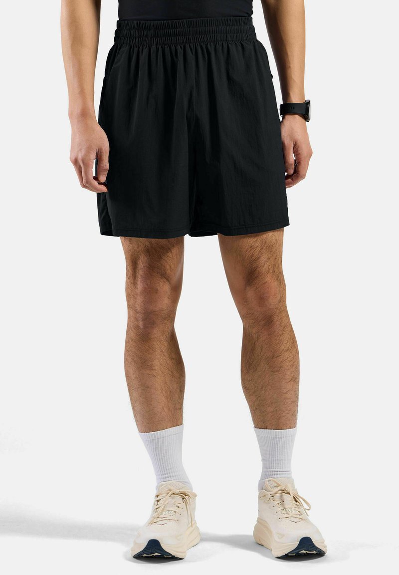 Zwarte shorts van lichte stof met een elastische tailleband, met een loose fit en tot halverwege de dijen reiken. Geen zichtbare zakken.