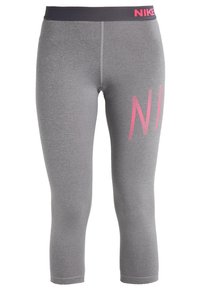 Graue Sportleggings aus elastischem Stoff mit einem schwarzen Bund, auf dem links "NIKE" in pinker Schrift steht.