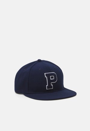 Casquette de baseball bleu marine avec une visière plate et une grande lettre "P" blanche en contour sur le panneau avant, sur un fond clair uni.