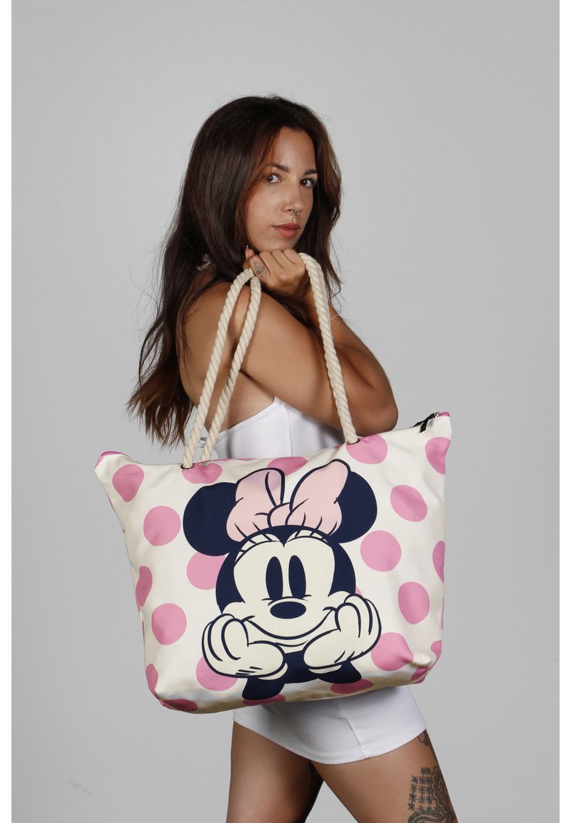 Stoffen tas met een grote afbeelding van Minnie Mouse met een roze strik, een crèmekleurige achtergrond en roze stippen. Ontworpen met touwhandvatten.