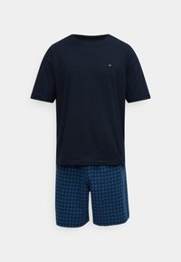 Μπλε βαμβακερό t-shirt με κοντά μανίκια, συνδυασμένο με μπλε σορτς που έχουν διαμαντένιο σχέδιο. Απλή, άνετη εφαρμογή κατάλληλη για αναψυχή.