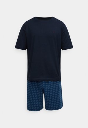 Tengerészkék rövid ujjú pamut póló, kék rövidnadrággal, amely gyémántmintával díszített. Egyszerű, kényelmes szabás, alkalmas szabadidős viselethez.