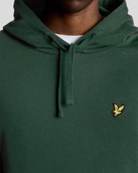 Hoodie vert en tissu doux, avec une capuche à cordon et un petit logo jaune d'un oiseau sur la poitrine. Texture lisse, design décontracté.