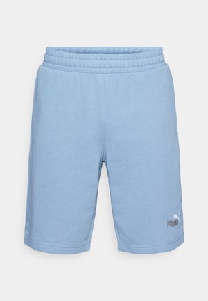 Lyseblå Puma-shorts med elastisk talje og logo på det nedre venstre ben, set fra front på hvid baggrund.