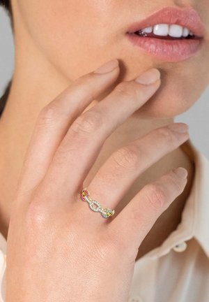 Strieborný prsteň so prepletenými článkami, ozdobený farebnými drahokamami v ružovej a žltej farbe. Dizajn je štíhly a elegantný, skvele zvýrazňuje ruku.