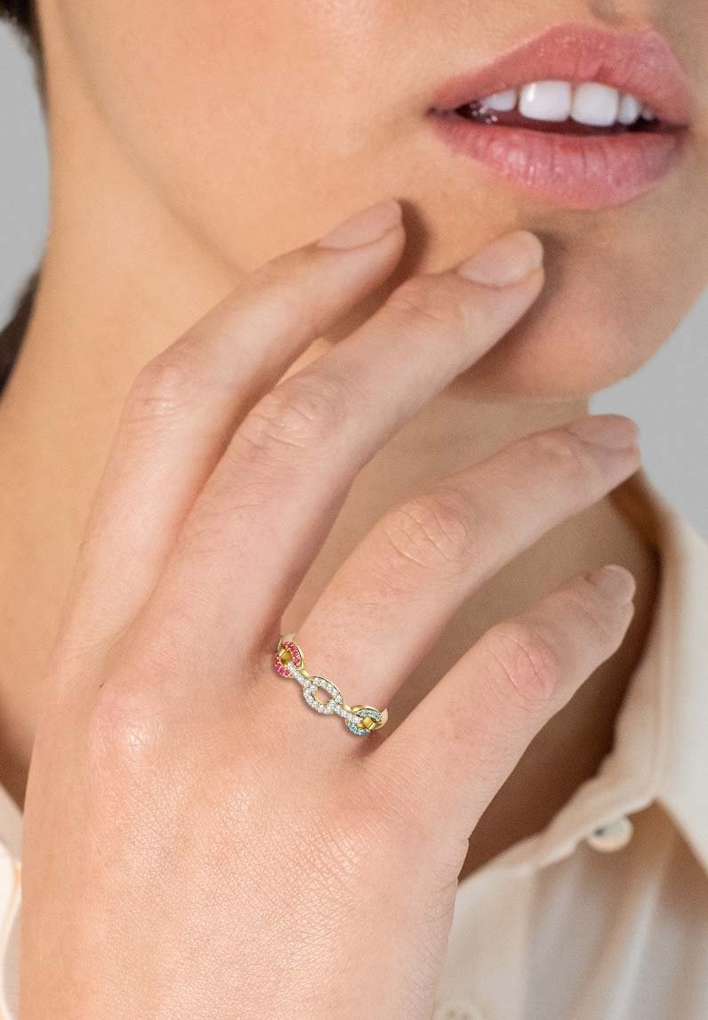 Strieborný prsteň so prepletenými článkami, ozdobený farebnými drahokamami v ružovej a žltej farbe. Dizajn je štíhly a elegantný, skvele zvýrazňuje ruku.