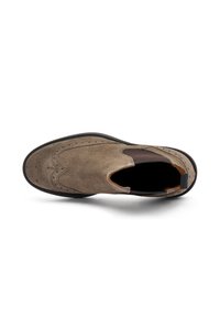 Zapato de ante marrón sin cordones con detalles de brogue perforados, paneles laterales elásticos y suela de goma texturizada. Perfil plano y punta redondeada.