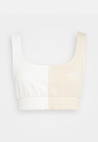 Půl bílé, půl béžové zkrácený top. Má čtvercový výstřih a elastický pas. Logo "PEGA" v bílé barvě na béžové straně. Měkká tkanina.