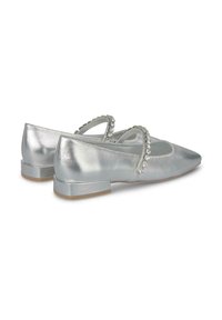 Ballerine in metallo argentato con punta affusolata, dotate di due fasce decorative decorate con zirconi trasparenti e un tacco basso a blocco.