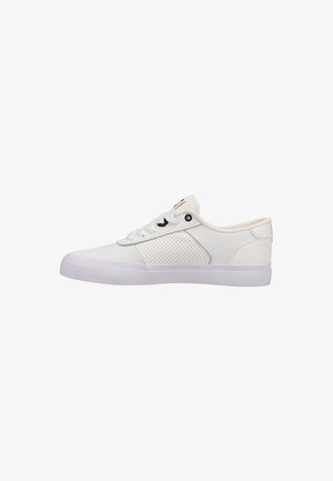 Zapatilla blanca baja con panel lateral perforado, cordones blancos y suela de goma, vista desde el lado exterior.