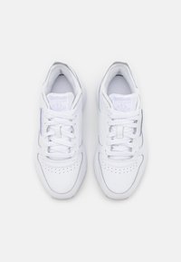 Paire de baskets blanches Reebok Classic avec lacets, vue de dessus sur fond blanc uni.