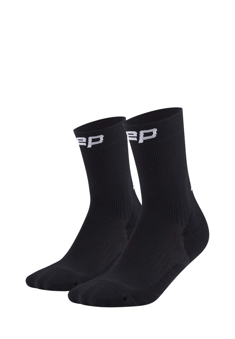 Calzini sportivi neri con texture a coste, lunghezza alla caviglia e logo bianco a contrasto sul risvolto. Realizzati in materiale traspirante.